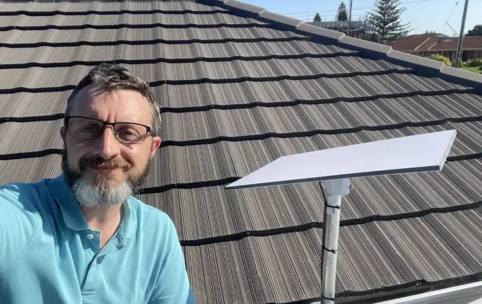 Engineer installing Starlink dish on roof